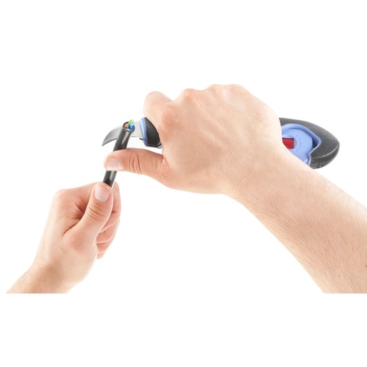 Photo of hands using Facom 872271 wire stripper on a black cable, white background, close-up.