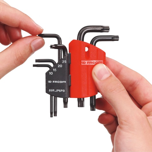 Photo of Facom 89R_JP6 Torx key set in red and black holder, held by two hands.