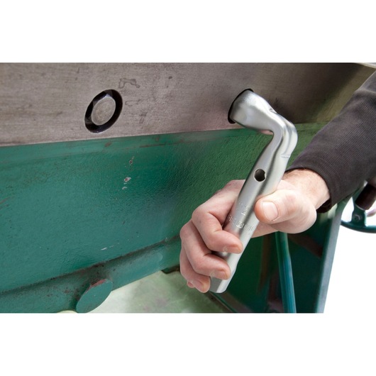 Facom 92A_22 angled socket wrench in use on metal machinery, close-up of hand gripping tool.