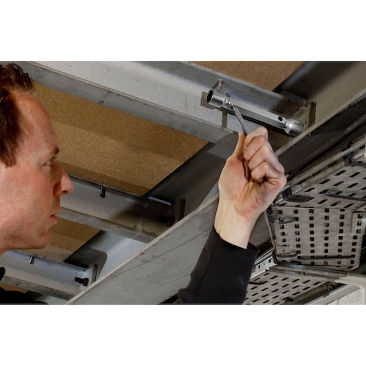 Photo of Facom 97_16X17 box spanner in use tightening a bolt on overhead metal structure.