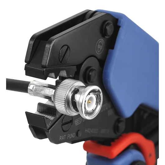 Facom cable crimping tool with blue and black handles, crimping a BNC connector, SKU 985758, close-up.