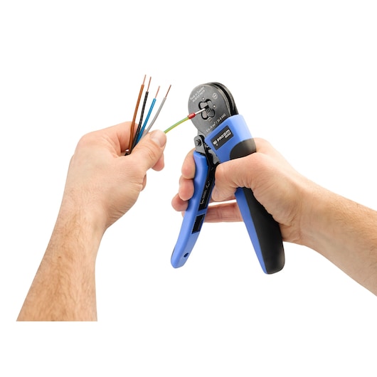 Photo of Facom 985905 wire stripper tool with blue handles, stripping insulation from colored electrical wires.