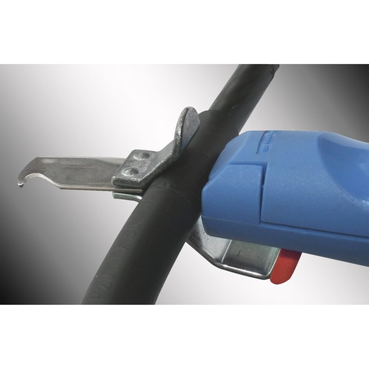 Facom 985956 cable stripper tool close-up with blue handle and metal blade cutting black cable.