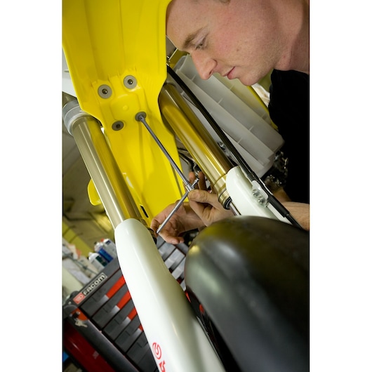 Facom 98B_8 photography of mechanic using tool on yellow motorcycle front suspension.