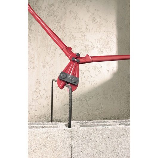 Facom 990_B1 bolt cutter cutting rebar, red handles, close-up, shown in masonry block.