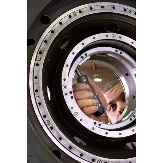 Photo of Facom A_442 screwdriver used inside a large metal machine component, worker in background.