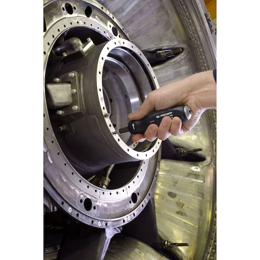 Photo of Facom A_444 screwdriver being used to tighten a screw on industrial metal machinery.