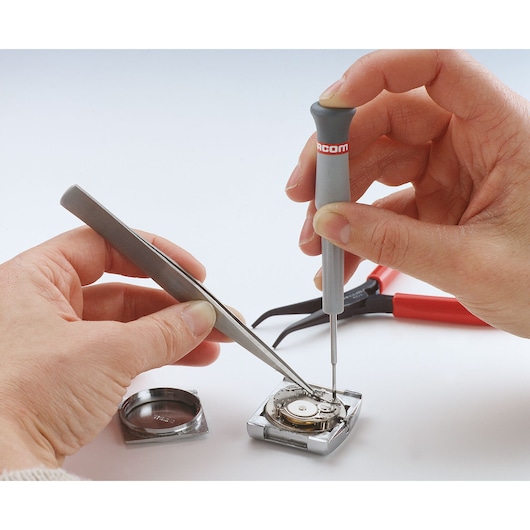 Facom precision screwdriver AEF_J1 used for watch repair, close-up photo with white background.