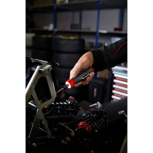 Photo of a Facom ATPA4V_J23PB insulated screwdriver with red and black handle used on machinery in a workshop.