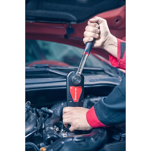 Facom AXS.LPB ratchet wrench in use on car engine, close-up photography.