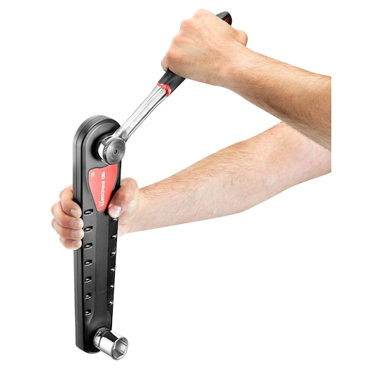 Photo of Facom AXS.LPB torque test tool in use, held by two hands on white background.