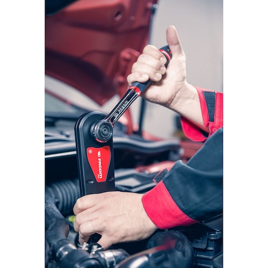 Photo of Facom AXS.SPB torque wrench being used by mechanic in car engine bay.