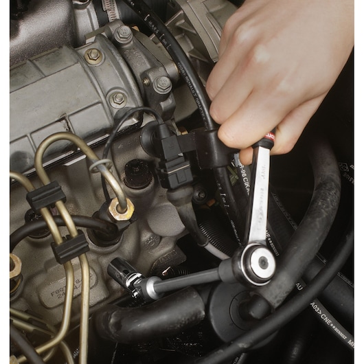 Facom B10R12AL ratcheting wrench in use on automotive engine components, close-up photography.