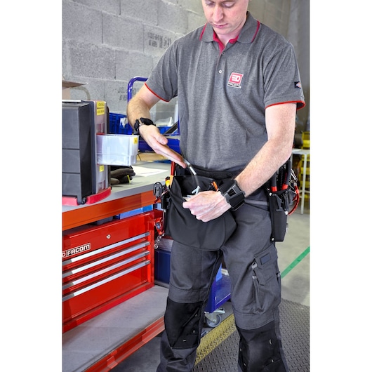 Facom BAG-BOLTSLS tool bag worn at waist, holding tools, in workshop setting.