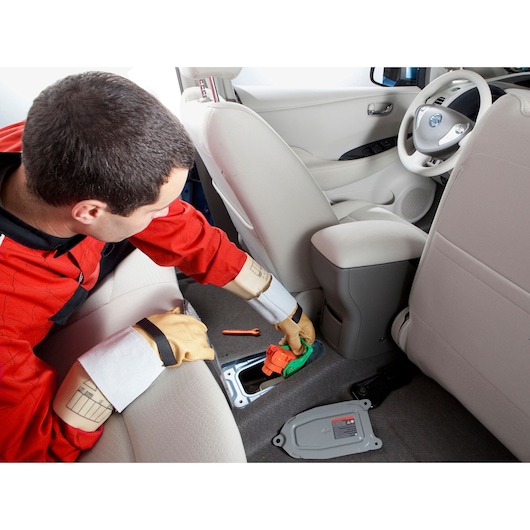 Facom BC_109VSE automotive service tool in use by technician wearing protective gloves inside vehicle.