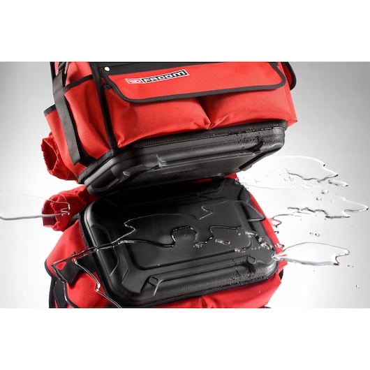 Facom BST14PB tool bag with water-resistant hard plastic base, shown with water on surface.