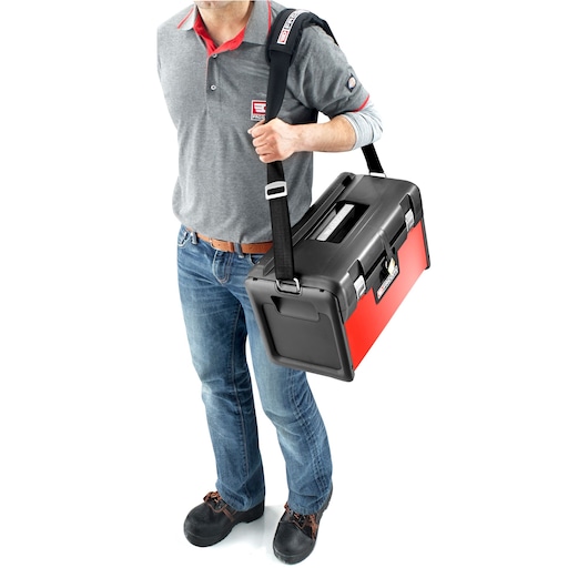 Facom BT200 toolbox with black shoulder strap, carried by person in grey polo, front angle.