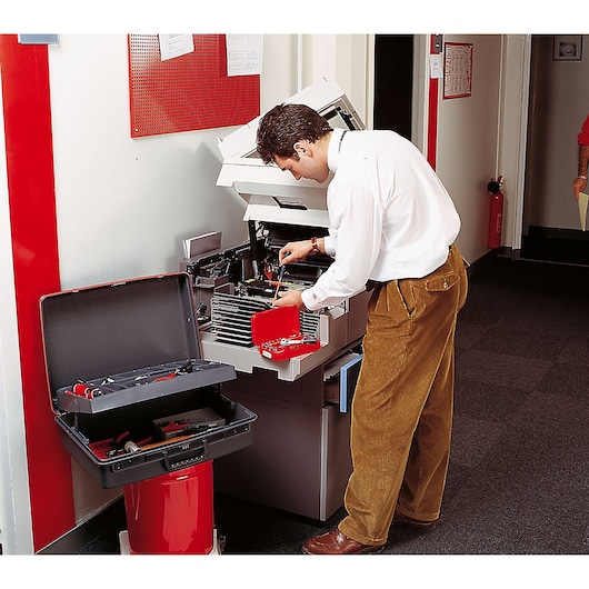 Facom BV_21ST photography of technician using tool kit to repair office copier.