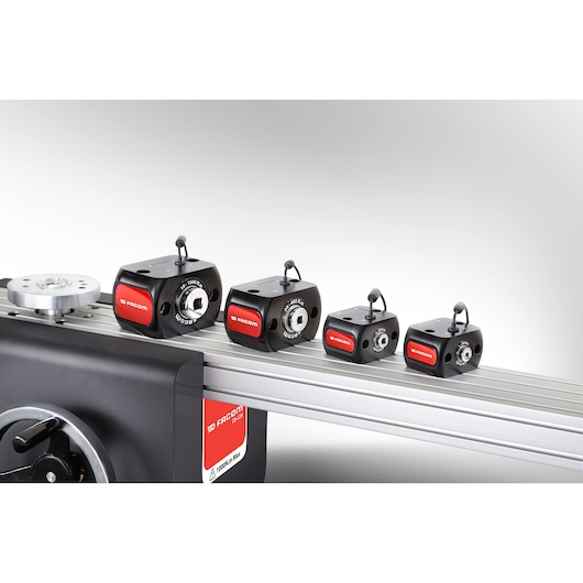 Facom CD12A photography of four torque calibrators in black and red on a metal rail, side angle.