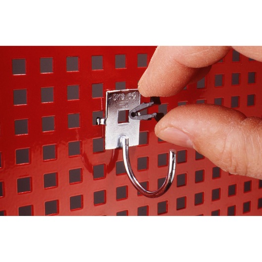 Facom CKLA metal hook being attached to a red perforated panel, close-up view with hand positioning the hook.