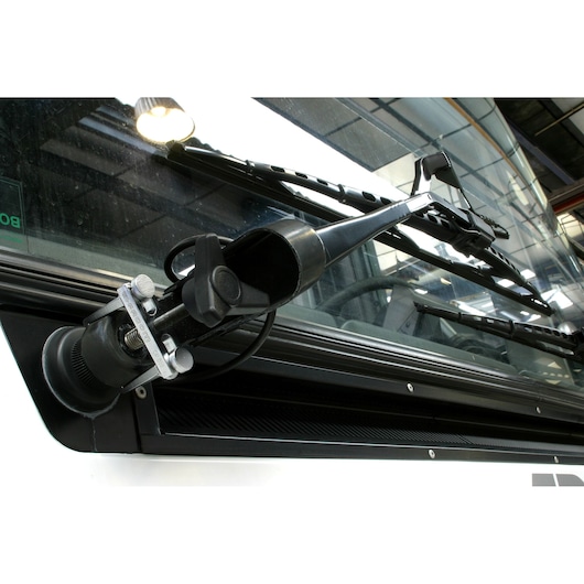 Facom CR_D10 wiper arm removal tool in use on vehicle windshield, close-up angle.