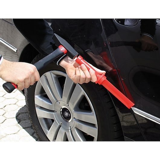 Facom CR.D4PB hammer and red pry bar tool used on car body near wheel, close-up outdoor.