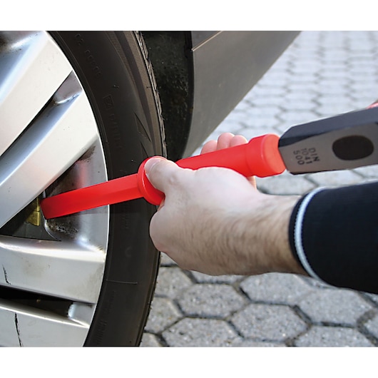 Photo of Facom CR.D4PB insulated chisel being used on a car wheel lug nut.