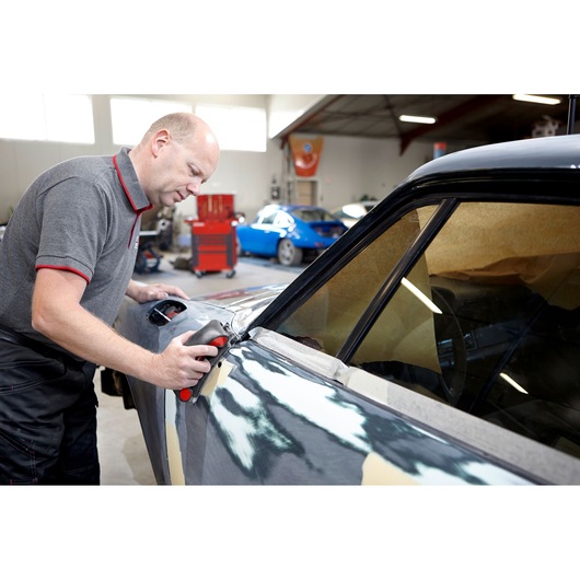 Facom CR_SBS photography of person sanding car body panel in workshop setting.