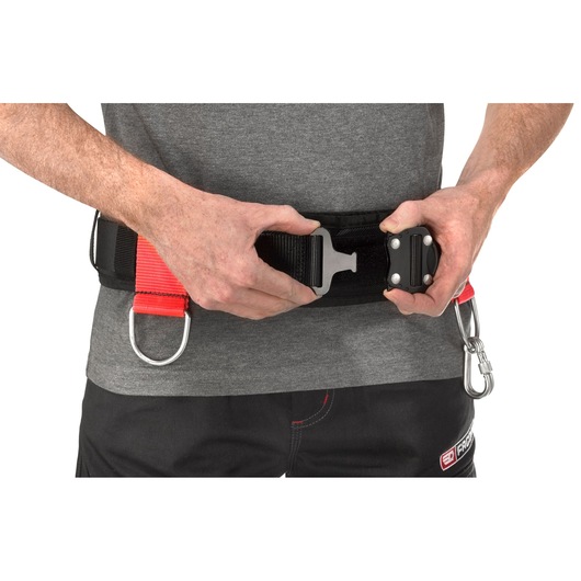 Facom CT-ACC photography of a person fastening a black and red safety belt with metal buckle and D-rings.