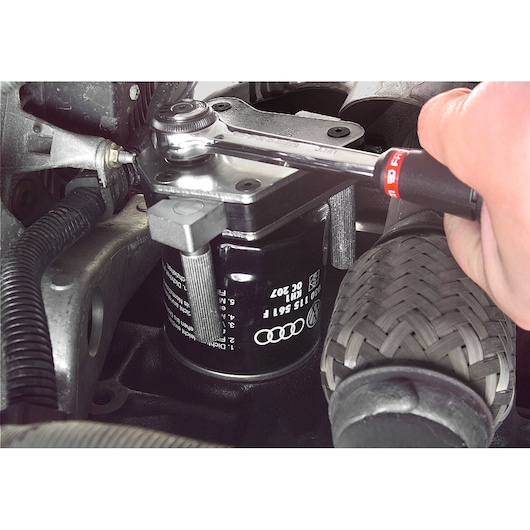 Facom D151A oil filter wrench in use, close-up on automotive engine components.