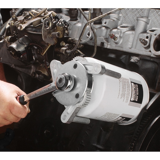 Facom D151PL oil filter wrench tool in use on automotive engine, close-up photography.