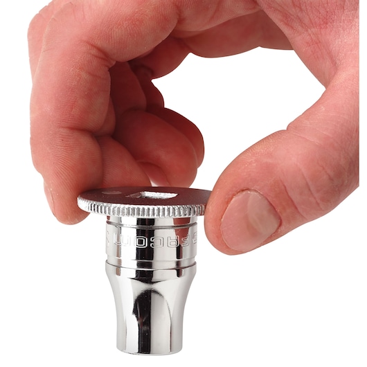 Photo of Facom D_169 chrome socket with knurled flange, held between fingers, white background, top angle.