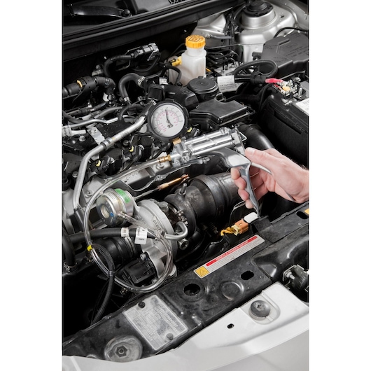 Facom DA_160 automotive pressure gauge in use on car engine, close-up photography.