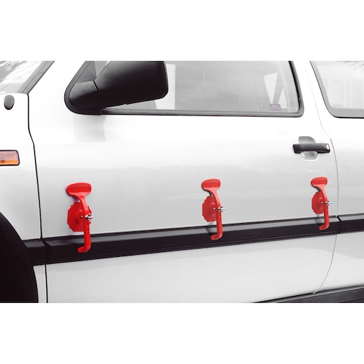 Photo of three red Facom DCR20J6 dent removal tools attached to the side of a white car.