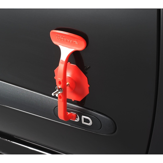 Facom DCR20J6 red lockout device attached to a black car door handle, close-up side view.