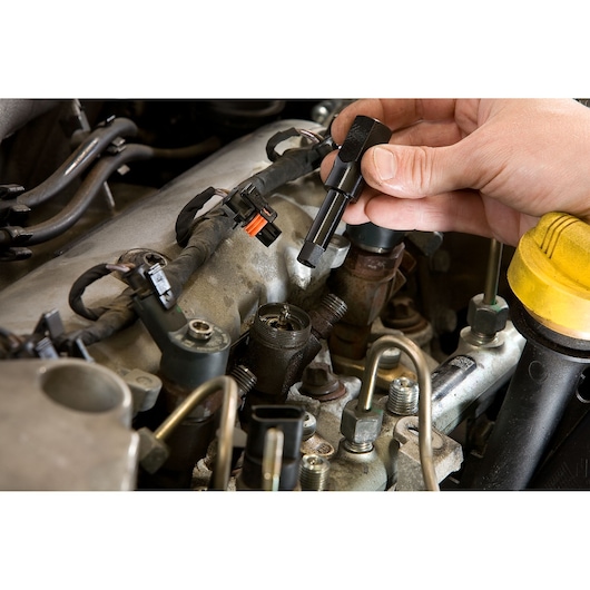 Facom DCRIP injector puller tool used inside an engine bay during automotive repair, close-up photography.