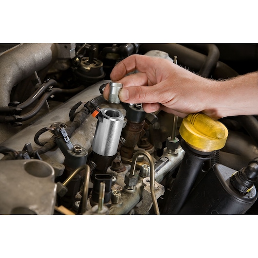 Facom DCRIP automotive tool used on engine injector during maintenance, close-up photography.