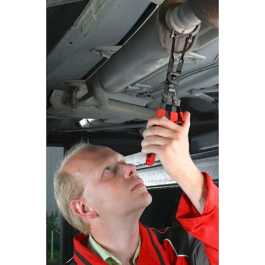 Facom DE.CAPB exhaust clamp pliers used by mechanic for removing exhaust system hanger under car.