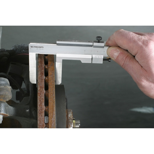 Facom DF_18-01 caliper measuring rusted metal part, close-up angle, photography product.
