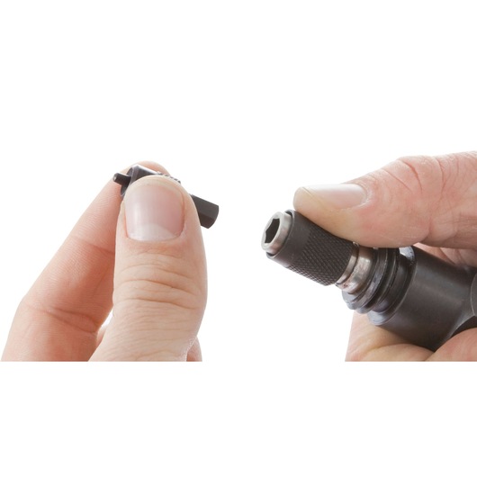 Facom DF475A close-up of hands inserting bit into black rotary tool with white background.