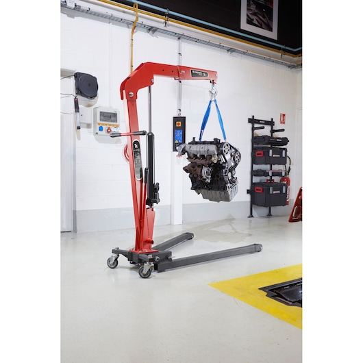 Facom DL_1GP hydraulic engine crane lifting an engine in a workshop, side angle.