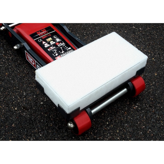 Facom DL_32ASUP floor jack pad with protective white cover attached, close-up angle, on asphalt surface.