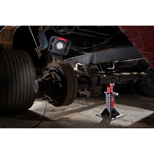 Facom DLPL22A photography of a heavy-duty vehicle axle with a Facom work light and a 22 ton jack stand.
