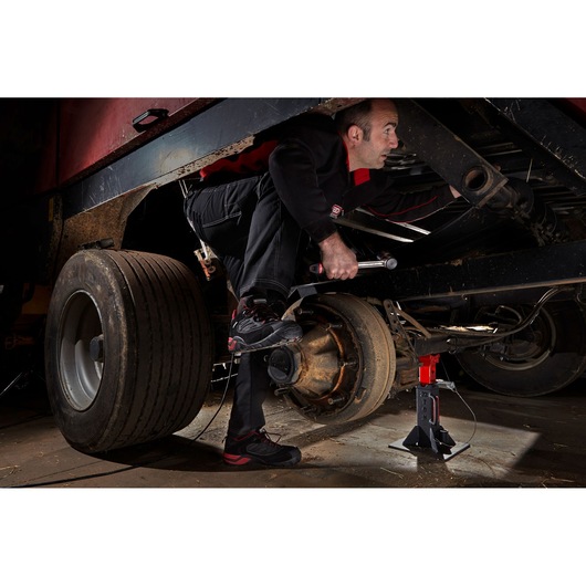 Facom DLPL22A photography of mechanic working on truck axle with jack stand and tire removed.
