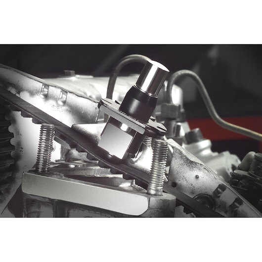 Facom DM_16 automotive tool in use on engine block, close-up photography showing detailed metal components.