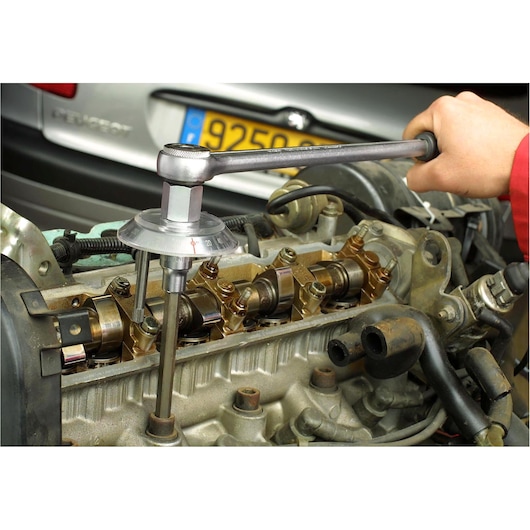 Facom DMP_360L torque angle gauge used on automotive engine, close-up of tool measuring angle.