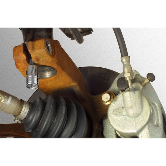 Facom DS_J5 socket used on a car suspension assembly, close-up photography showing application on metal parts.