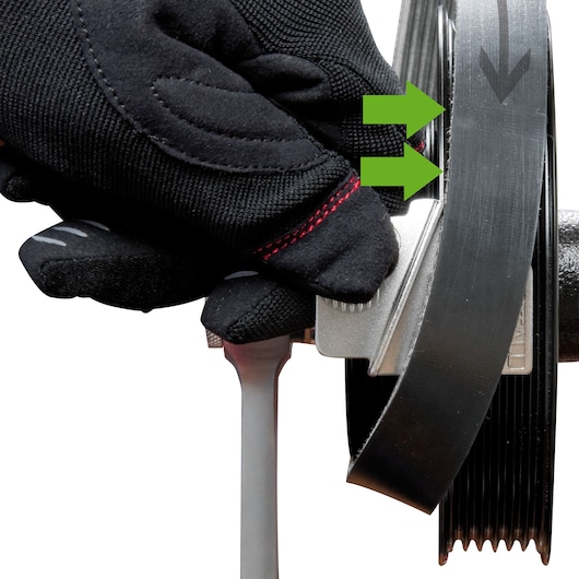 Facom DT_SFB photography showing gloved hand using tool to adjust black pulley belt, close-up angle.