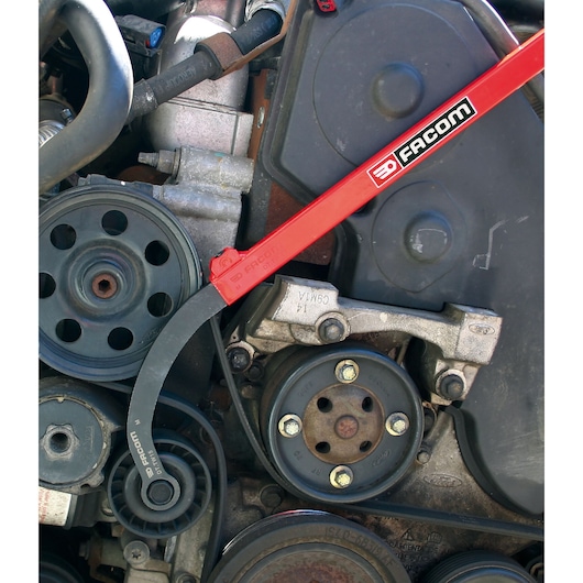 Photo of Facom DT_TW16 belt tensioner tool in use on a car engine, showing pulleys and components.