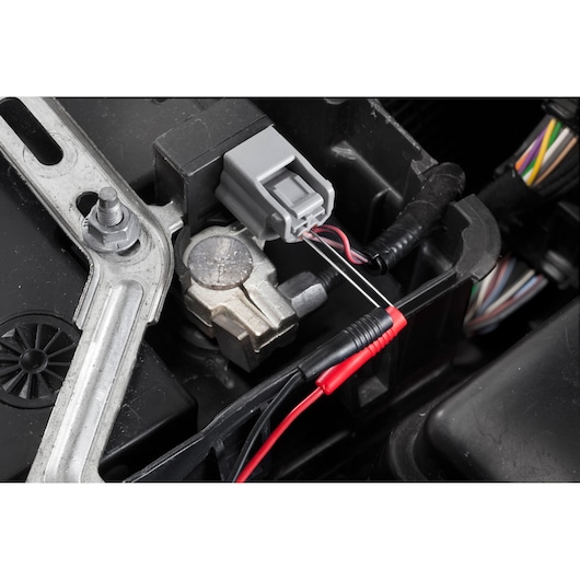 Facom DX_SET automotive electrical connector with multimeter test leads attached, close-up detail.